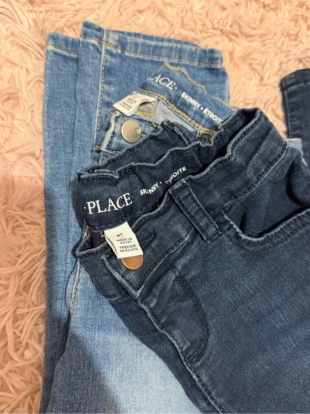 Two pair of Children's Place Girls' Skinny Jeans - Dark Blue and Light Blue.